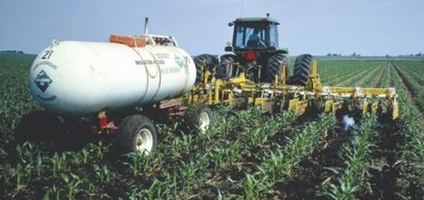 Tractor spreading nitrogen fertiliser on a corn field